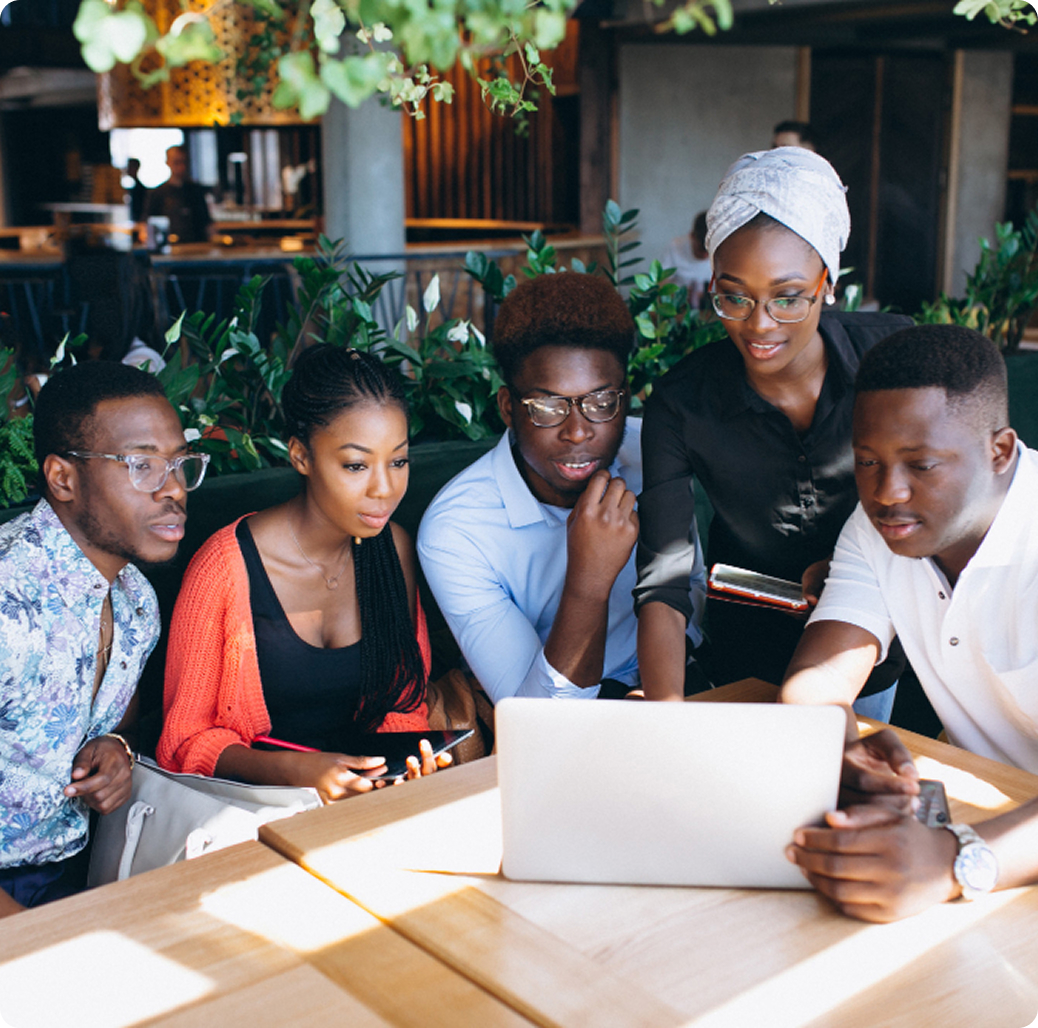 Technology professionals collaborating around a laptop during a mentorship session.